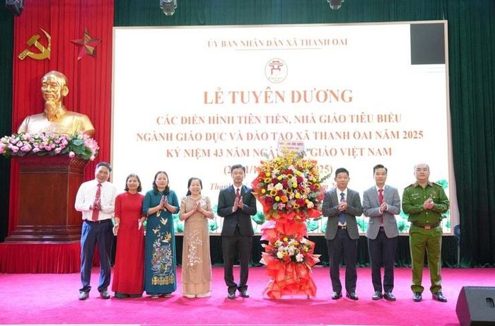 Lãnh đạo xã Thanh Oai tặng hoa chúc mừng ngành Giáo dục - Đào tạo xã. Ảnh: Nguyễn Lý