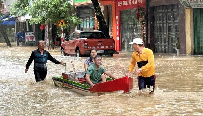 Dùng ghe thuyền di dời người dân đến nơi an toàn. Ảnh: Tường Quân - TTXVN