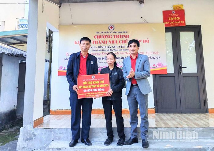 Lãnh đạo Hội Chữ thập đỏ tỉnh đại diện cho nhà tài trợ trao biển tượng trưng hỗ trợ kinh phí để sửa chữa nhà ở cho gia đình bà Nguyễn Thị Tiếp.