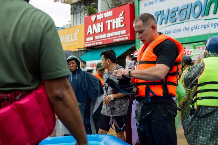  Một người đàn ông nước ngoài đang liên lạc mua áo phao, tham gia cứu trợ bà con trên đường 23 Tháng 10 chiều 20/11. Ảnh: Quỳnh Long Hải. 