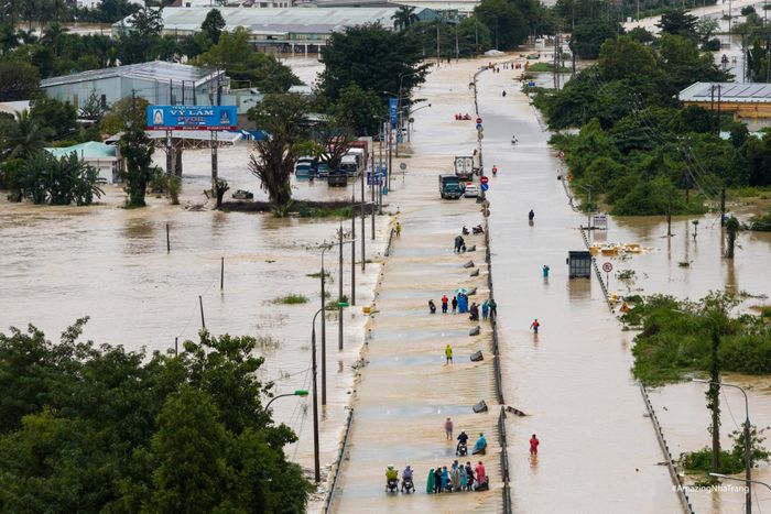  Dòng người khó khăn di chuyển qua Quốc lộ 1C, đoạn xã Diên Phú cũ (nay thuộc xã Diên Điền). Trước diễn biến phức tạp của mưa lũ, chính quyền Khánh Hòa đã huy động quy mô lớn lực lượng cứu hộ. Hơn 300 sĩ quan và chiến sĩ hải quân thuộc Vùng 4 và Học viện Hải quân được triển khai ngay trong đêm để tiếp cận các khu vực ngập sâu, đưa người già, trẻ nhỏ và người mắc kẹt ra khỏi vùng nguy hiểm. Ảnh: Quỳnh Long Hải. 