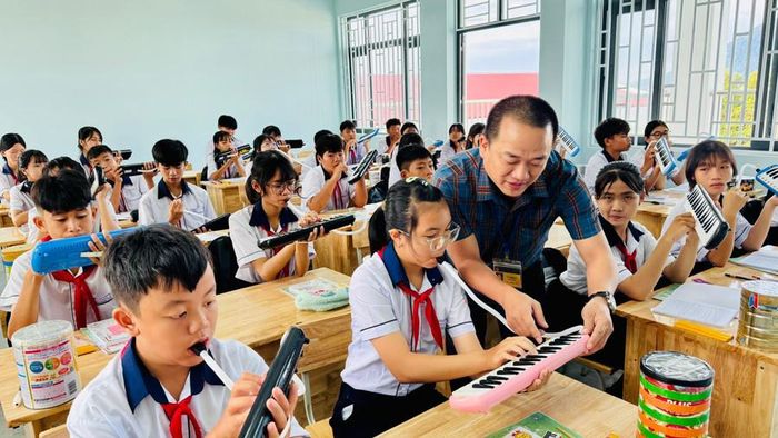  Thầy Tú hướng dẫn học sinh sử dụng kèn phím. 