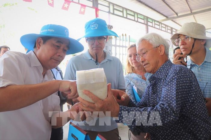 Ông Phạm Thái Bình, Tổng Giám đốc Công ty Cổ phần Nông nghiệp công nghệ cao Trung An (phải) chia sẻ về gạo hữu cơ, giảm phát thải. Ảnh: Thu Hiền - TTXVN