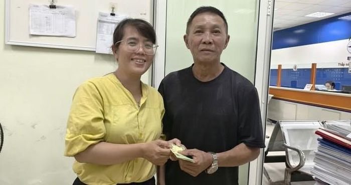 Nhân viên ngành điện trao trả tài sản để quên cho khách hàng.