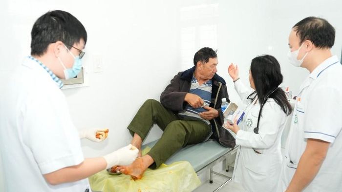 Các bác sĩ trong đoàn công tác trực tiếp xử trí một ca cấp cứu chấn thương bàn chân cho người.