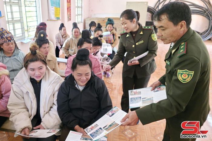 Cán bộ Hạt Kiểm lâm khu vực VI phát tờ rơi tuyên truyền công tác bảo vệ rừng cho nhân dân xã Phiêng Pằn.