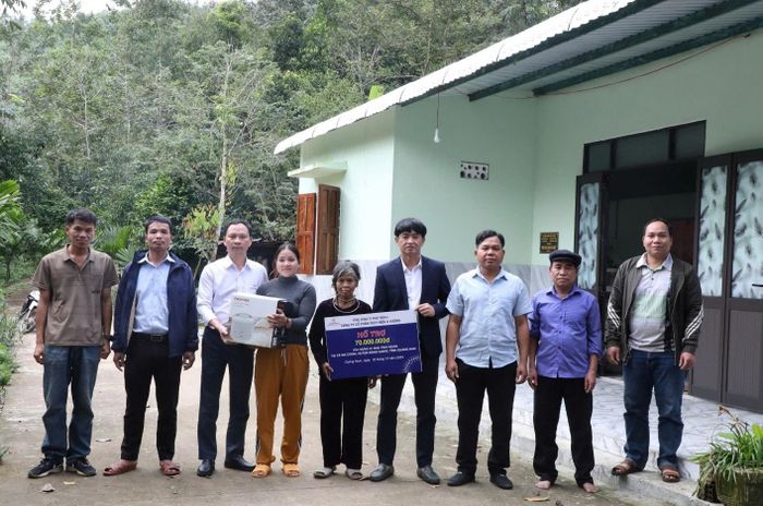 Công ty CP Thủy điện A Vương trao hỗ trợ xây dựng nhà đại đoàn kết cho người dân tại xã Bến Hiên. Ảnh: VĂN LÃM