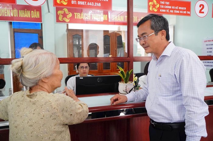 Phó Chủ tịch Ủy ban MTTQ Việt Nam thành phố Nguyễn Phi Hùng thăm hỏi một cụ bà ở xã Khâm Đức trong chuyến giám sát hoạt động Trung tâm Phục vụ hành chính công tại địa phương này. Ảnh: VINH ANH