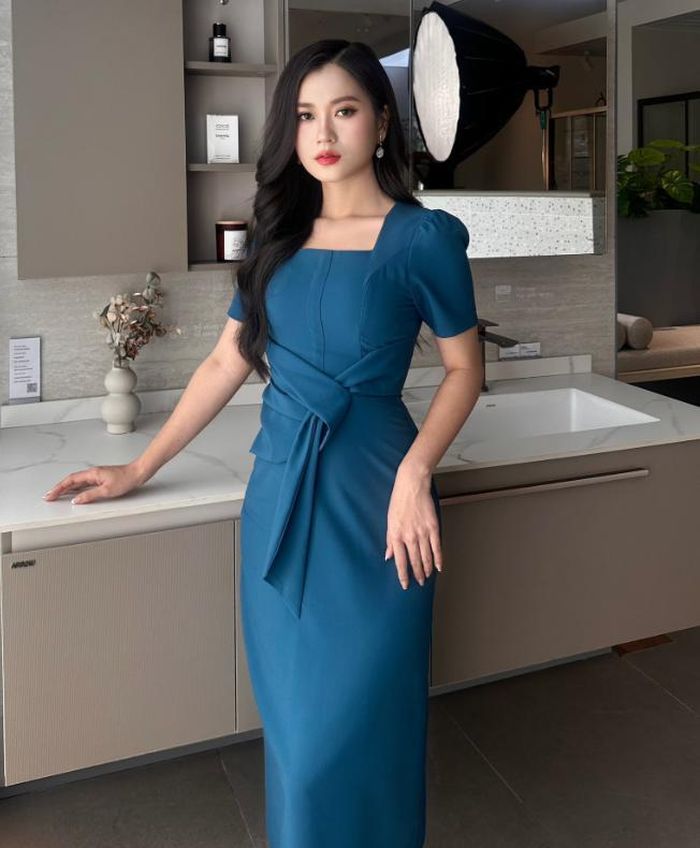 Cô thường lựa chọn các thiết kế đầm liền thân với đường cắt may tinh xảo, nhấn nhá vào vòng eo để tạo phom dáng đồng hồ cát. Một ví dụ điển hình là chiếc đầm xanh ngọc với chi tiết thắt eo duyên dáng và cổ vuông trang nhã. Ảnh: FBNV 