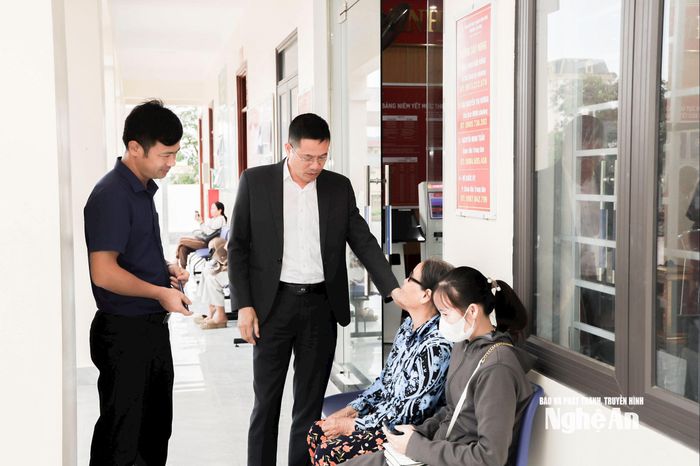 Lãnh đạo phường Tân Mai trao đổi cùng người dân đến làm thủ tục hành chính tại Trung tâm Phục vụ hành chính công phường. Ảnh: Nguyên Nguyên