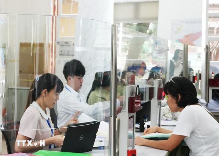 Cán bộ, công chức tại Trung tâm Hành chính công Quận 1 (phường Sài Gòn mới) đang khẩn trương xử lý hồ sơ. (Ảnh: Hữu Duyên/TTXVN)