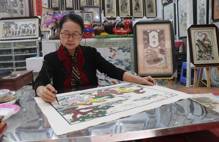Nghệ nhân ưu tú Nguyễn Thị Oanh sáng tạo, bảo tồn tranh dân gian Đông Hồ. Ảnh: Thái Hùng - TTXVN