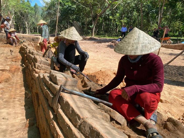 Quá trình khai quật đã phát hiện tường bao hai bên được xếp từ các hàng gạch. Ảnh: VĨNH LỘC