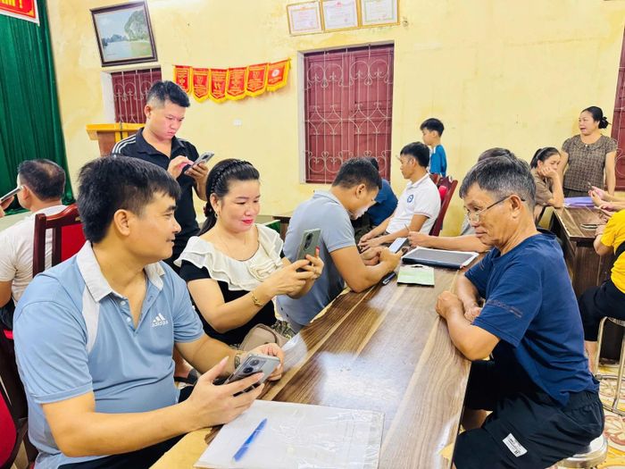 Tổ công nghệ số cộng đồng thôn 3, xã Mường Lát hướng dẫn người dân sử dụng ứng dụng VNeID