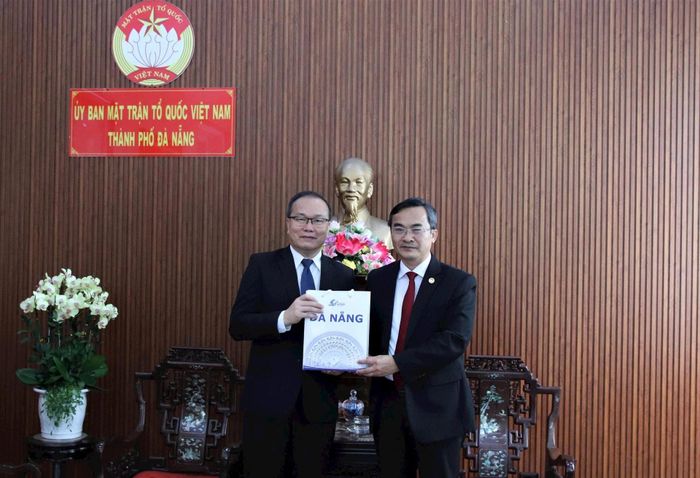 Phó Chủ tịch Ủy ban MTTQ Việt Nam thành phố Nguyễn Phi Hùng (bên phải) tặng quà lưu niệm cho ông Souphanh Hadaoheuang. Ảnh: TRỌNG HUY