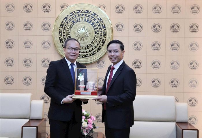 Chủ tịch UBND thành phố Phạm Đức Ấn (bên phải) tặng quà lưu niệm cho ông Souphanh Hadaoheuang. Ảnh: TRỌNG HUY