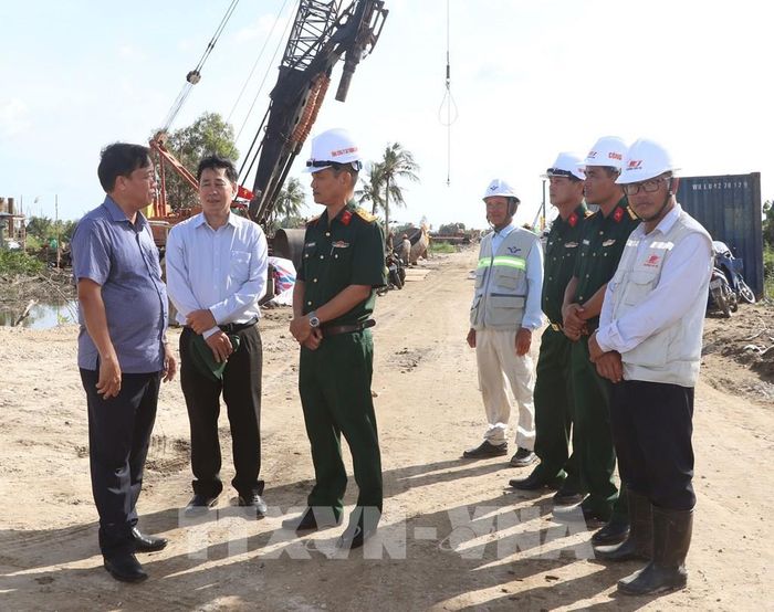 Phó Bí thư Thường trực Tỉnh ủy Cà Mau Huỳnh Quốc Việt thăm hỏi, động viên công nhân trên công trường. Ảnh: Tuấn Phi - TTXVN