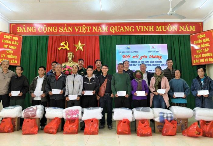 Đại diện Hội Thiện hữu thành phố Đà Nẵng và Đồn Biên phòng Đắc Pring trao quà động viên các già làng, gia đình chính sách trên địa bàn xã. Ảnh: TRỊNH TÙNG