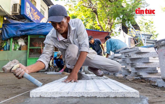 Đội thi công làm việc liên tục không nghỉ tay để kịp bàn giao vỉa hè cho người dân vào cuối năm 2025.