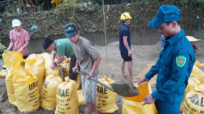 Các lực lượng xung kích xã Thu Bồn gia cố tạm tại các vị trí sạt lở. Ảnh: HỒ QUÂN