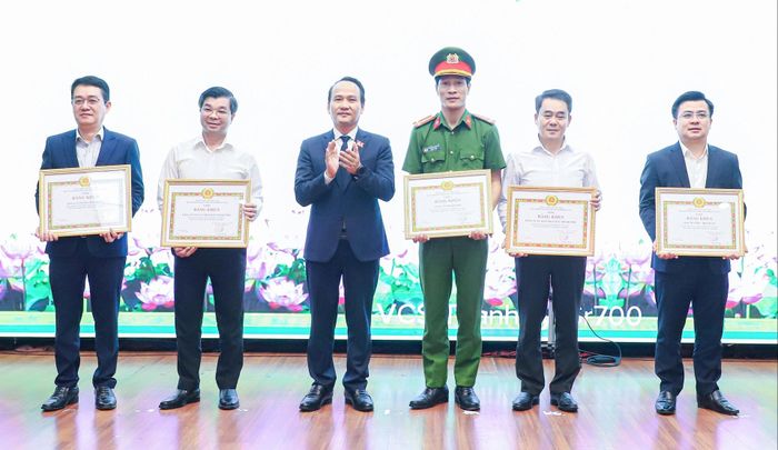 Phó Bí thư Thường trực Thành ủy Nguyễn Đình Vĩnh (thứ 3, bên trái sang) trao bằng khen của Ban Thường vụ Thành ủy cho các tập thể. Ảnh: NGỌC PHÚ