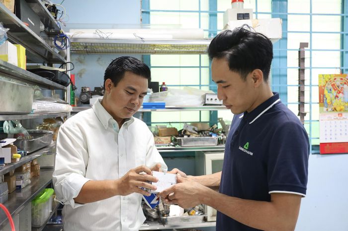 Anh Trương Văn Hiếu hướng dẫn nhân viên làm việc. Ảnh: BẢO HÂN