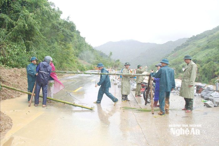 Cán bộ nhân viên Ban Chỉ huy Phòng thủ khu vực 4 – Tương Dương phối hợp với lực lượng Dân quâ tự vệ xã Tương Dương và cấp ủy chính quyền địa phương tiến hành lập hàng rào cảnh bảo các khu vực nguy hiểm cho bà con nhân dân do sạt lỡ đất trên địa bàn xã Tương Dương. Ảnh: Trọng Kiên