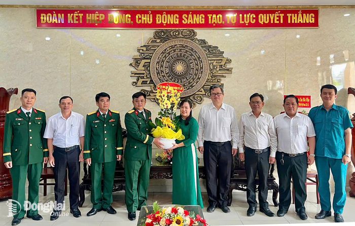 Phó Bí thư Thường trực Đảng ủy phường Trảng Dài Trần Nguyễn Thảo Ly và đoàn lãnh đạo phường tặng hoa chúc mừng đơn vị Lữ đoàn Tăng thiết giáp 22 - Binh chủng Tăng thiết giáp. Ảnh: Xuân Nương