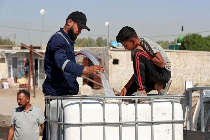 Người dân xếp hàng lấy nước tại điểm phân phối ở miền Trung Iraq. Ảnh: Karrar Jabbar/AFP/Getty Images