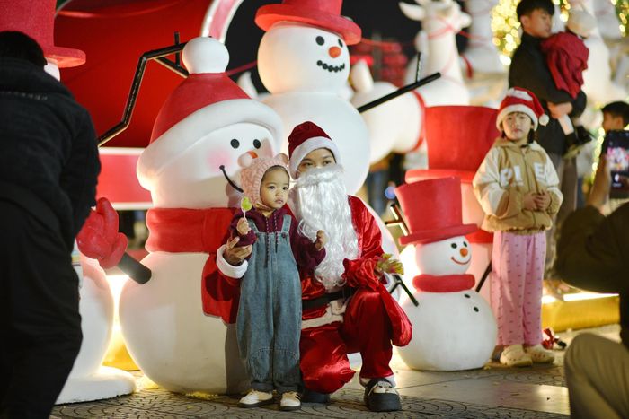 Em nhỏ chụp hình cùng ông già Noel. Ảnh: HOÀNG DŨNG