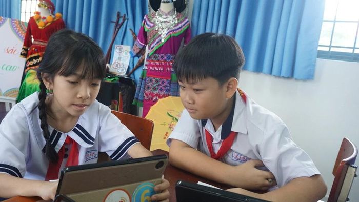  Học sinh Trường Tiểu học Võ Thị Sáu, phường Tân Thới Hiệp sử dụng máy tính bảng để tham gia các trò chơi trong tiết học sau khi được giáo viên hướng dẫn. Ảnh: NGUYỄN QUYÊN 