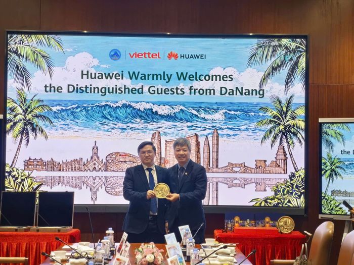 Phó Chủ tịch UBND thành phố Hồ Quang Bửu (bên phải) tặng quà lưu niệm cho ông Zhu Xiu Jin, Chủ tịch Bộ phận kinh doanh số hóa dịch vụ hành chính công Tập đoàn Hua wei. Ảnh: HỒNG HẠNH