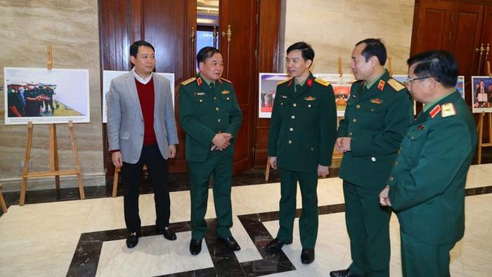  Các đại biểu trao đổi và tham quan khu trưng bày hình ảnh về công tác khắc phục hậu quả bom mìn, chất độc hóa học bên lề hội nghị. 