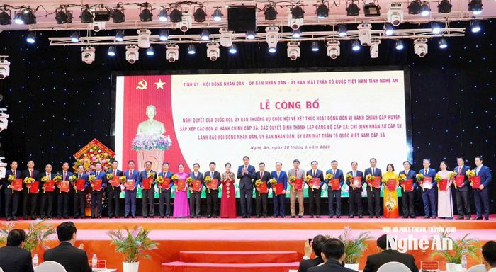 Các đồng chí: Hoàng Nghĩa Hiếu - Phó Bí thư Thường trực Tỉnh ủy, Chủ tịch HĐND tỉnh; Võ Thị Minh Sinh - Phó Bí thư Tỉnh ủy, Chủ tịch Ủy ban MTTQ Việt Nam tỉnh, Trưởng đoàn ĐBQH tỉnh Nghệ An trao các quyết định đến 130 Bí thư Đảng ủy xã, phường. Ảnh: Phạm Bằng