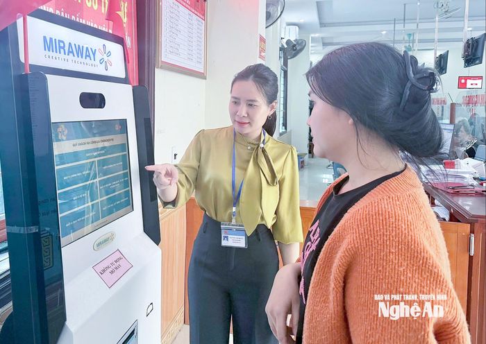 Cán bộ Trung tâm Phục vụ hành chính công xã Nghi Lộc hướng dẫn người dân lấy số thứ tự giải quyết thủ tục hành chính. Ảnh: Mai Hoa