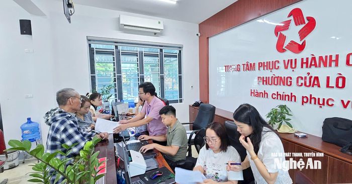Cán bộ, công chức UBND phường Cửa Lò hướng dẫn, giải quyết và trả kết quả thủ tục hành chính cho người dân trong ngày thứ Bảy. Ảnh: Mai Hoa