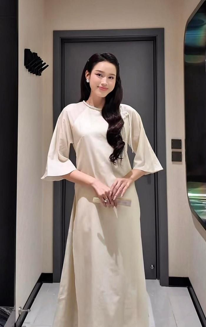 Tiếp nối tinh thần Á Đông, Đỗ Thị Hà ưu ái thiết kế lụa kết hợp tơ nhũ ánh nhẹ đầy tinh tế. Điểm nhấn của bộ trang phục nằm ở phần thân áo dệt hoa văn chìm, tay raglan suông rộng phóng khoáng và cổ trụ nhỏ với hàng khuy bọc thủ công tinh xảo. Khi được phối cùng quần lụa hồng pastel, bộ cánh không chỉ tôn lên nét thanh lịch đặc trưng của người phụ nữ Việt mà còn mang lại cảm giác nhẹ nhàng, bay bổng. Ảnh: FBNV 