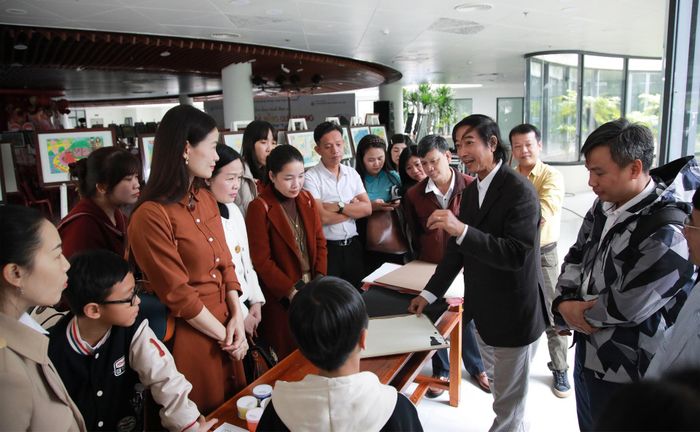 Các thầy cô giáo, học sinh trải nghiệm và in tranh dưới sự hướng dẫn của các họa sĩ. Ảnh: ĐẮC MẠNH