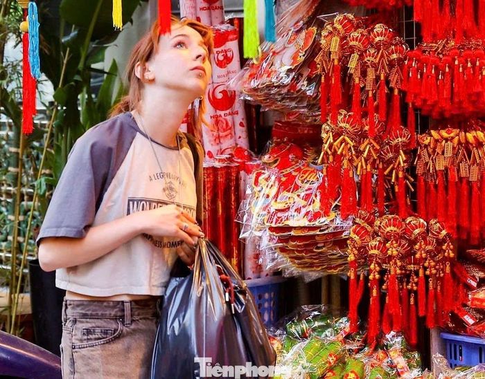Du khách nước ngoài thích thú dạo phố và mua sắm đồ trang trí Tết.