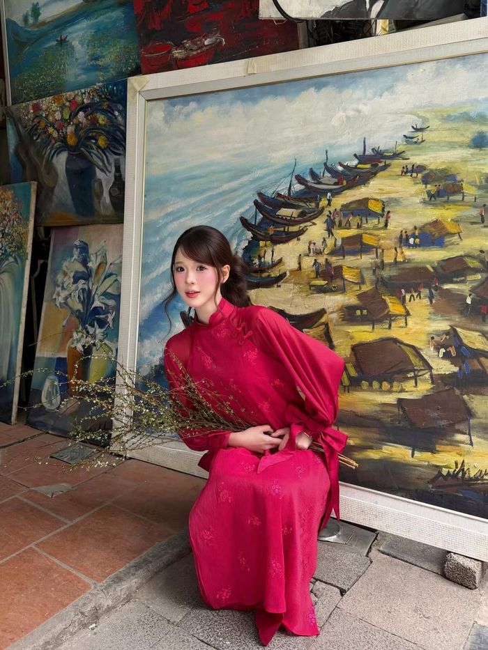 Sự kết hợp giữa tà áo dài đỏ nổi bật cùng những cành tuyết mai trắng muốt - loài hoa đặc trưng của mùa xuân miền Bắc - đã tạo nên một tổng thể vô cùng hài hòa và đậm chất thơ. (Ảnh: IGNV)