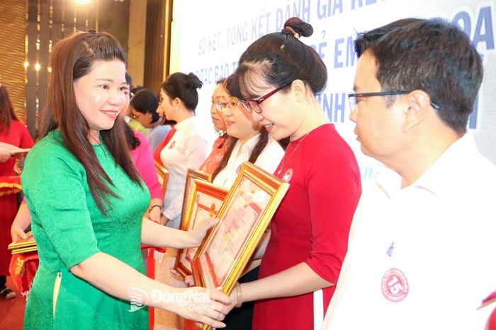 Phó Giám đốc Sở Y tế tỉnh Đồng Nai Phạm Thị Mai Hương trao bằng khen của UBND tỉnh cho các cá nhân và tập thể có thành tích xuất sắc trong thực hiện công tác bảo trợ xã hội, trẻ em giai đoạn 2021-2025 trên địa bàn tỉnh Đồng Nai. Ảnh: Văn Truyên