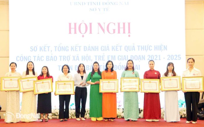 Phó Giám đốc Sở Y tế tỉnh Đồng Nai Phạm Thị Mai Hương trao bằng khen của UBND tỉnh cho các cá nhân và tập thể có thành tích xuất sắc trong thực hiện công tác bảo trợ xã hội, trẻ em giai đoạn 2021-2025 trên địa bàn tỉnh Đồng Nai. Ảnh: Văn Truyên
