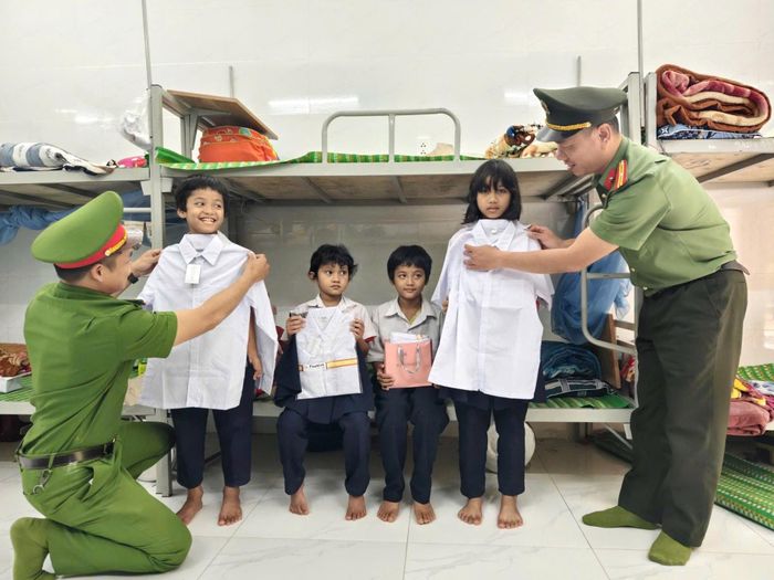 Chi đoàn Công an xã Avương tặng đồng phục, đồ dùng học tập mới cho học sinh khó khăn. Ảnh: L.P