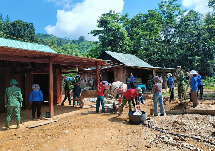 Các lực lượng biên phòng, dân quân, thanh niên ở xã Đắc Pring giúp người dân vùng thiên tai dựng nhà an cư. Ảnh: HỒ QUÂN