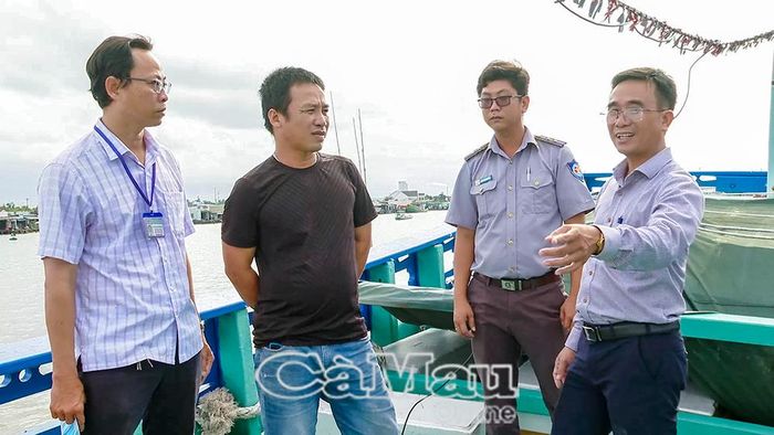 Ông Phạm Văn Mười, Phó Giám đốc Sở Nông nghiệp và Môi trường tỉnh Cà Mau (bìa phải) tuyên truyền, phổ biến các quy định chống khai thác IUU cho ngư dân tại cửa biển Sông Đốc.