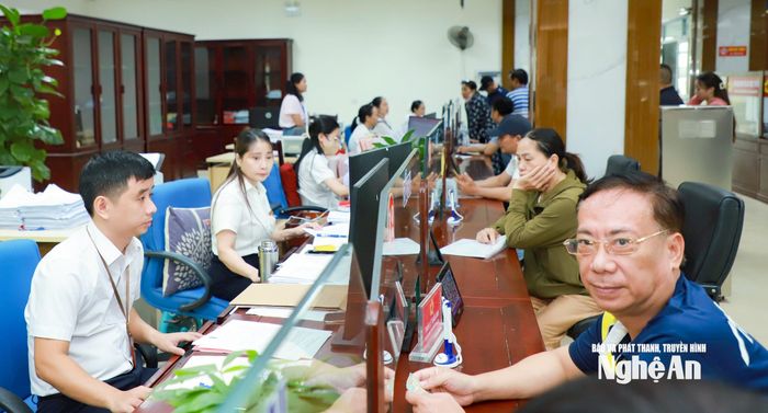 Cán bộ, công chức phường Thành Vinh tiếp nhận thủ tục hành chính cho người dân tại Trung tâm phục vụ hành chính công. Ảnh: Thành Duy