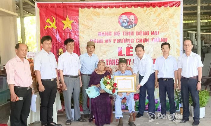 Đồng chí Hà Duy Đạt, Phó Bí thư Thường trực Đảng ủy, Chủ tịch HĐND phường Chơn Thành, trao Huy hiệu 55 năm tuổi Đảng cho đồng chí Lê Đình Tư. Ảnh: Đỗ Trình