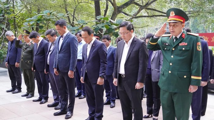 Các đại biểu dành phút mặc niệm tại Di tích Quốc gia đặc biệt Hang Tám Cô - Ảnh: Q.V