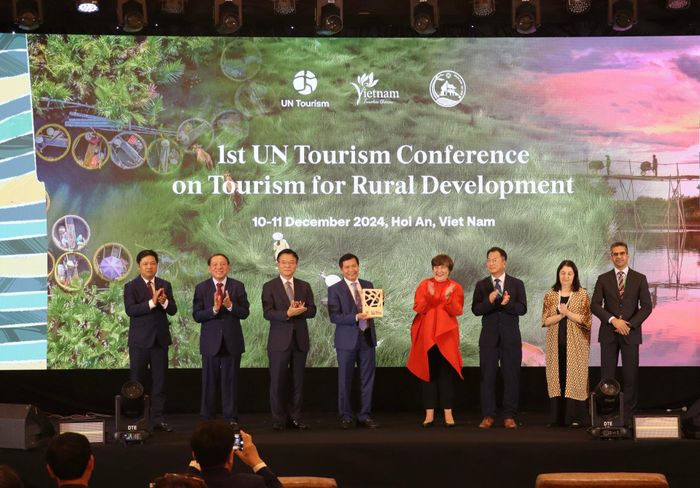 Đại diện Tổ chức Du lịch Liên Hợp Quốc (thứ 4 từ phải qua) trao danh hiệu "Làng du lịch tốt nhất năm 2024" cho đại diện làng rau Trà Quế. Ảnh: QUỐC TUẤN