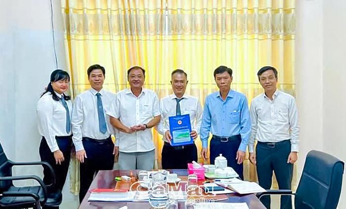 Ông Vưu Nghị Bình, Giám đốc Sở Tư pháp tỉnh Cà Mau (thứ ba từ trái sang), trao Quyết định hợp nhất và Quyết định chỉ định Ban Chủ nhiệm lâm thời Đoàn Luật sư tỉnh Cà Mau cho Luật sư Nguyễn Duy Sơn.
